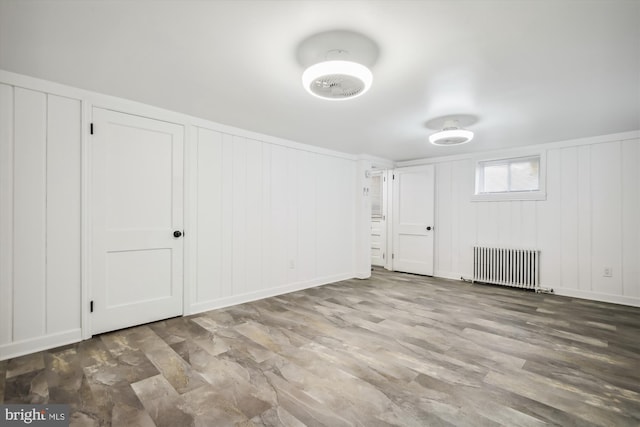 empty room with hardwood / wood-style floors and radiator heating unit