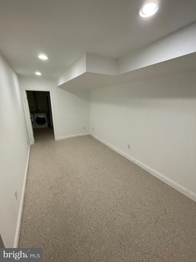 basement featuring washer / dryer and light carpet