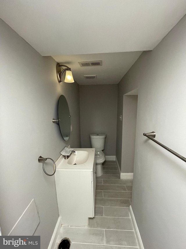 bathroom featuring vanity, tile flooring, and toilet