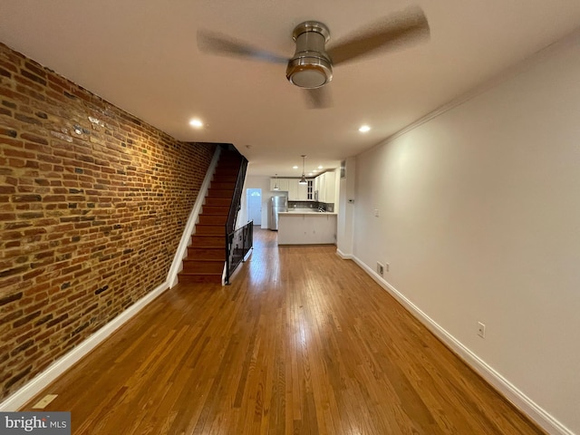 hall with dark hardwood / wood-style flooring, brick wall, and ornamental molding