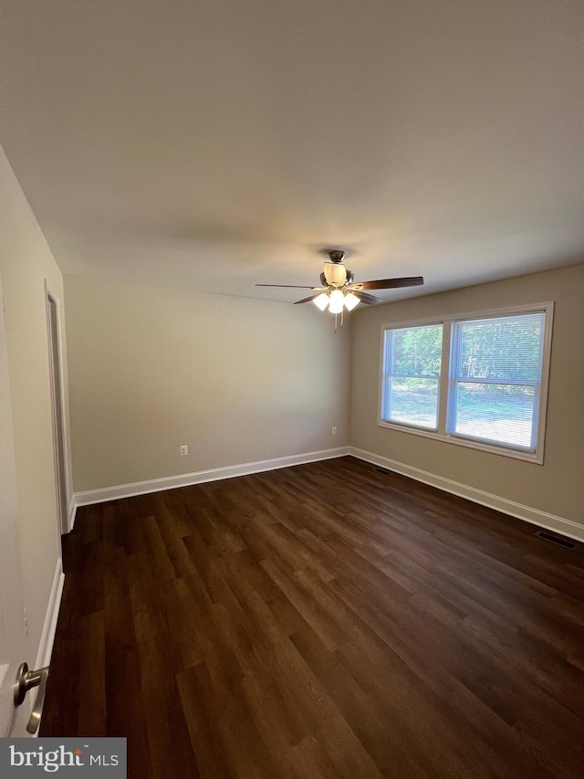 empty room with dark hardwood / wood-style flooring and ceiling fan