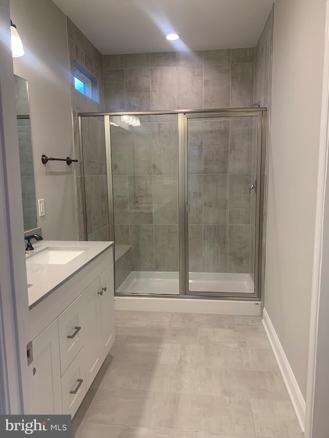 bathroom featuring tile floors, oversized vanity, and an enclosed shower