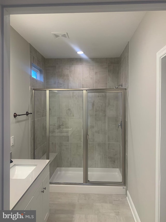 bathroom featuring walk in shower and vanity