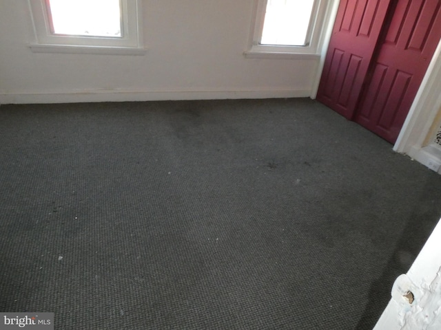 unfurnished bedroom with carpet and multiple windows