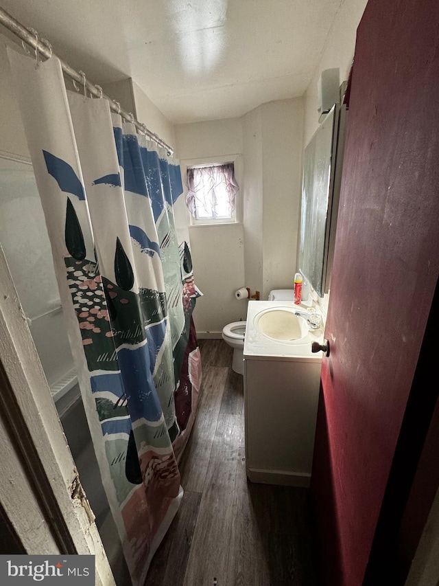 bathroom with a shower with shower curtain, vanity, toilet, and wood-type flooring