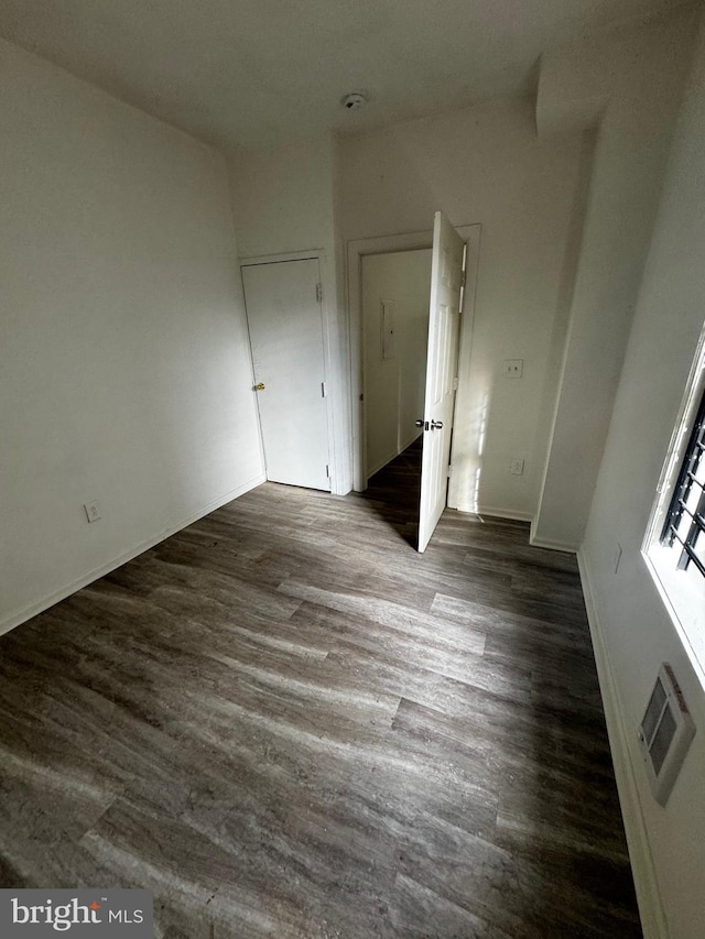 spare room featuring dark wood-type flooring