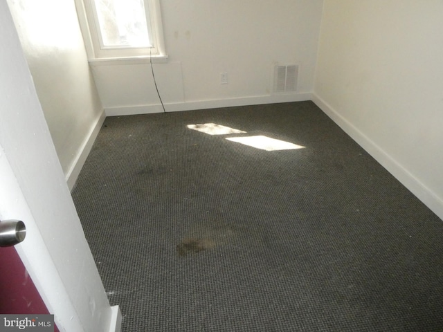 spare room with dark carpet