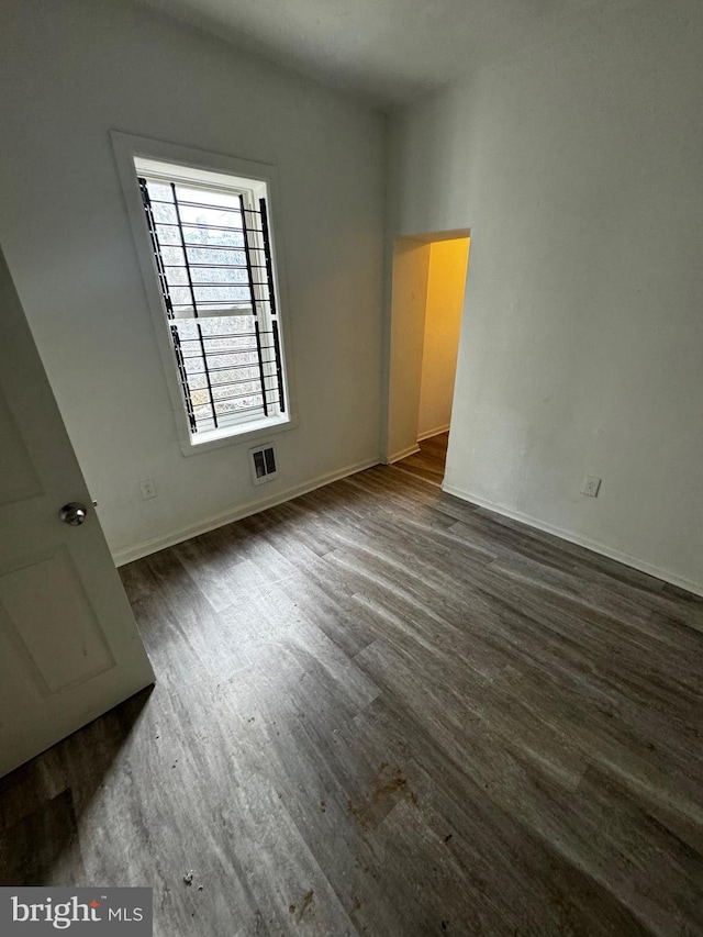 spare room featuring dark wood-type flooring