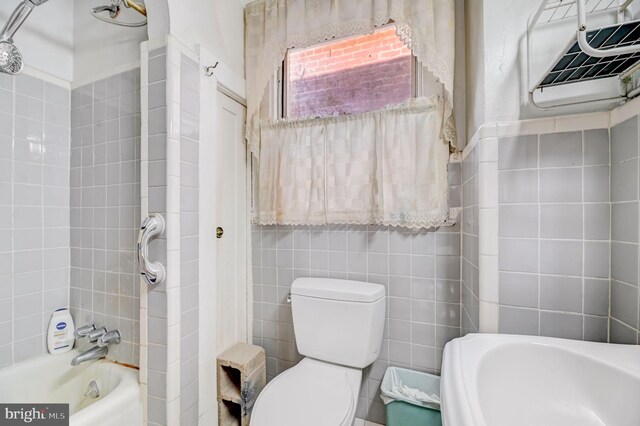 bathroom with tile walls and toilet