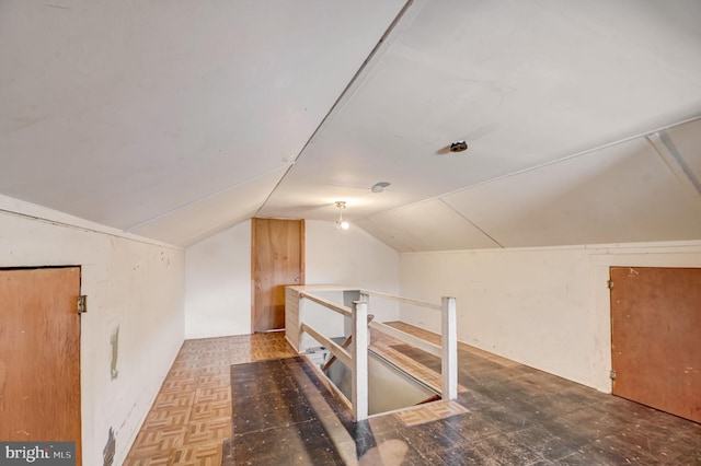 bonus room featuring lofted ceiling and parquet floors