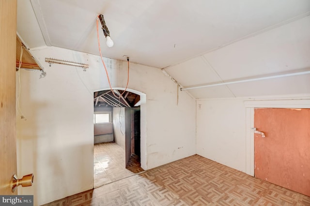 additional living space with light parquet floors and vaulted ceiling