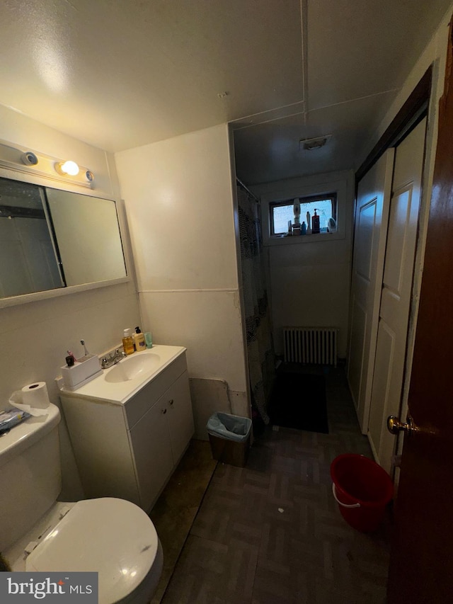 bathroom with vanity, parquet floors, radiator, toilet, and curtained shower