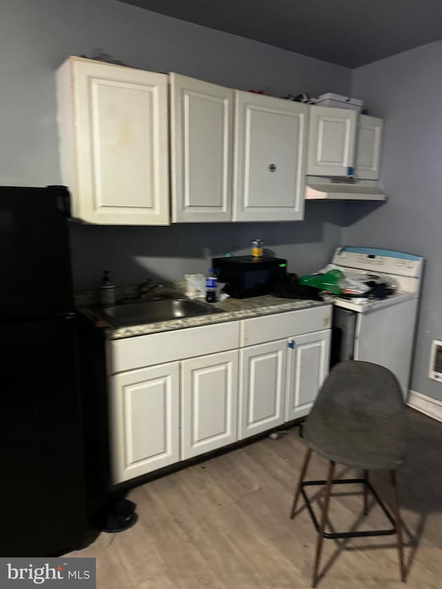 kitchen featuring light hardwood / wood-style floors, sink, electric range, and white cabinets