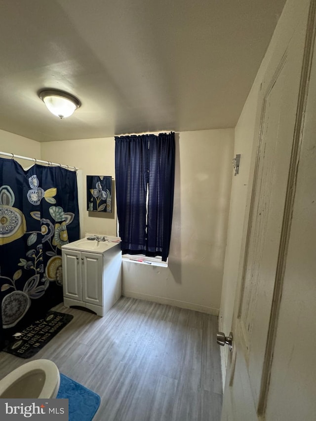 bathroom with a shower with curtain, vanity, and hardwood / wood-style flooring