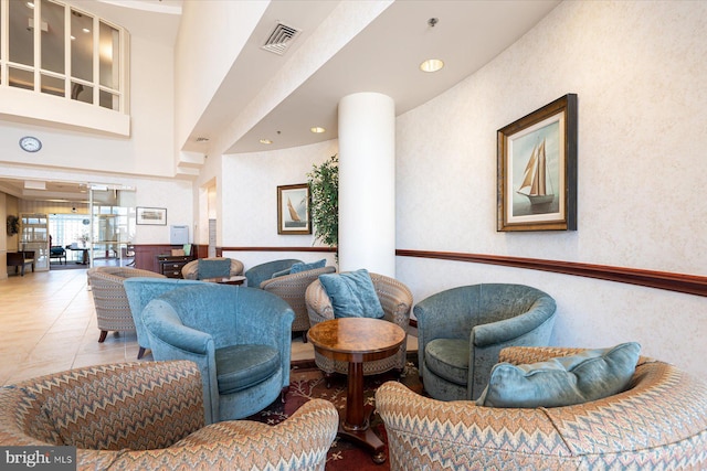 tiled living room featuring a towering ceiling