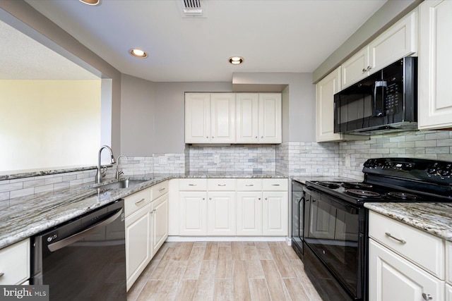 kitchen with black appliances, white cabinets, and a sink