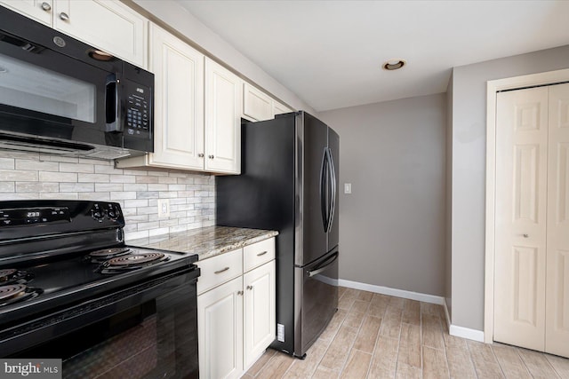 kitchen featuring white cabinetry, black appliances, light stone counters, and light hardwood / wood-style floors