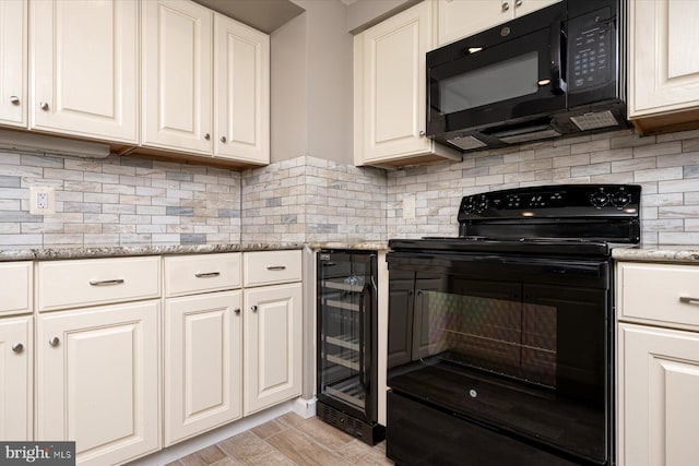 kitchen with light stone countertops, tasteful backsplash, beverage cooler, black appliances, and light hardwood / wood-style floors