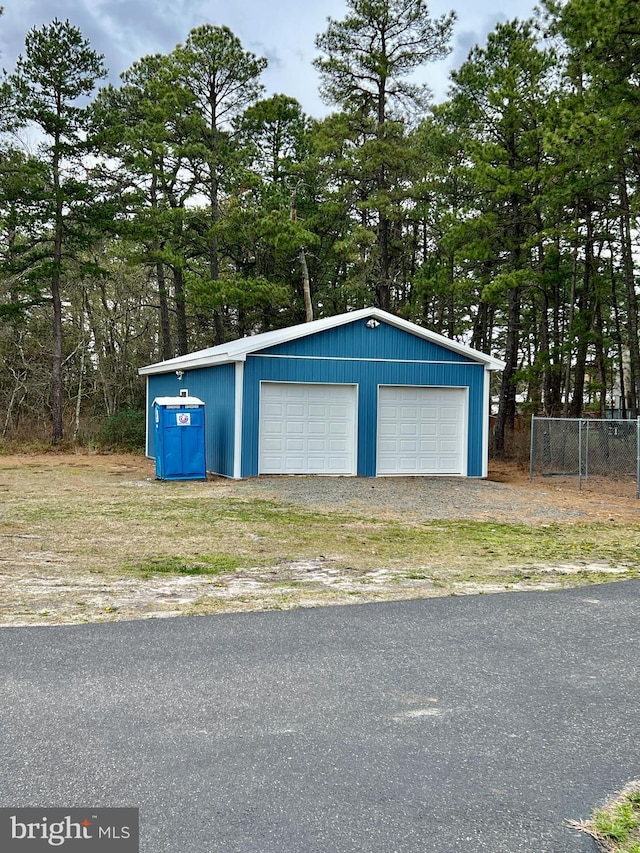 detached garage featuring fence