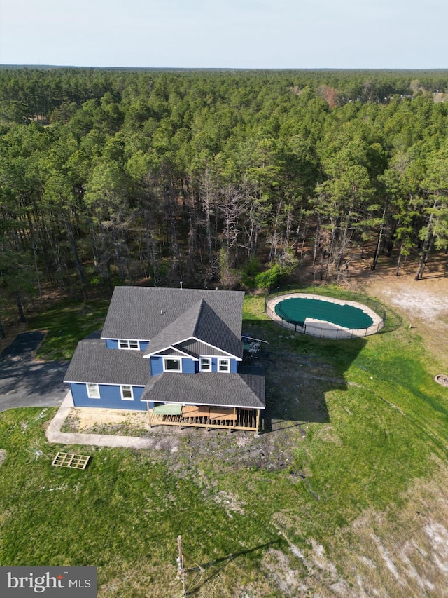 drone / aerial view featuring a wooded view