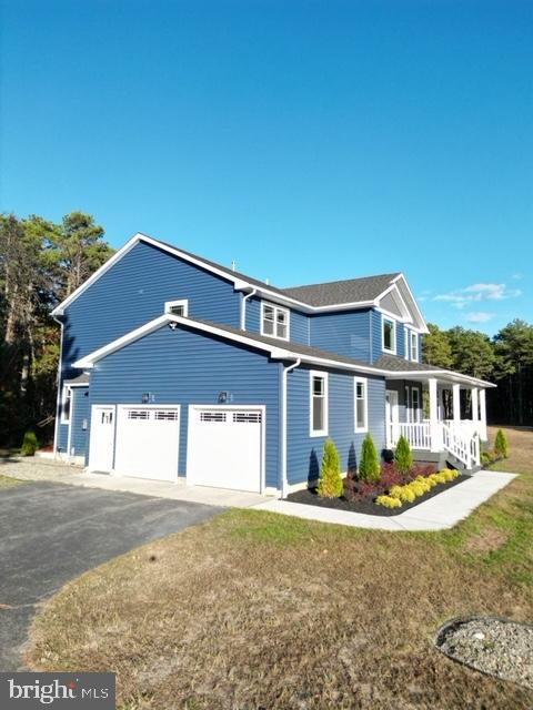 view of front of home with covered porch, driveway, and an attached garage