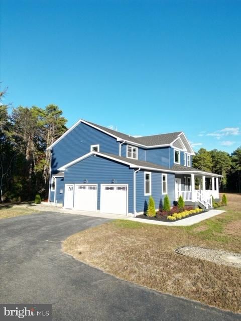 view of front facade featuring aphalt driveway, a porch, and an attached garage