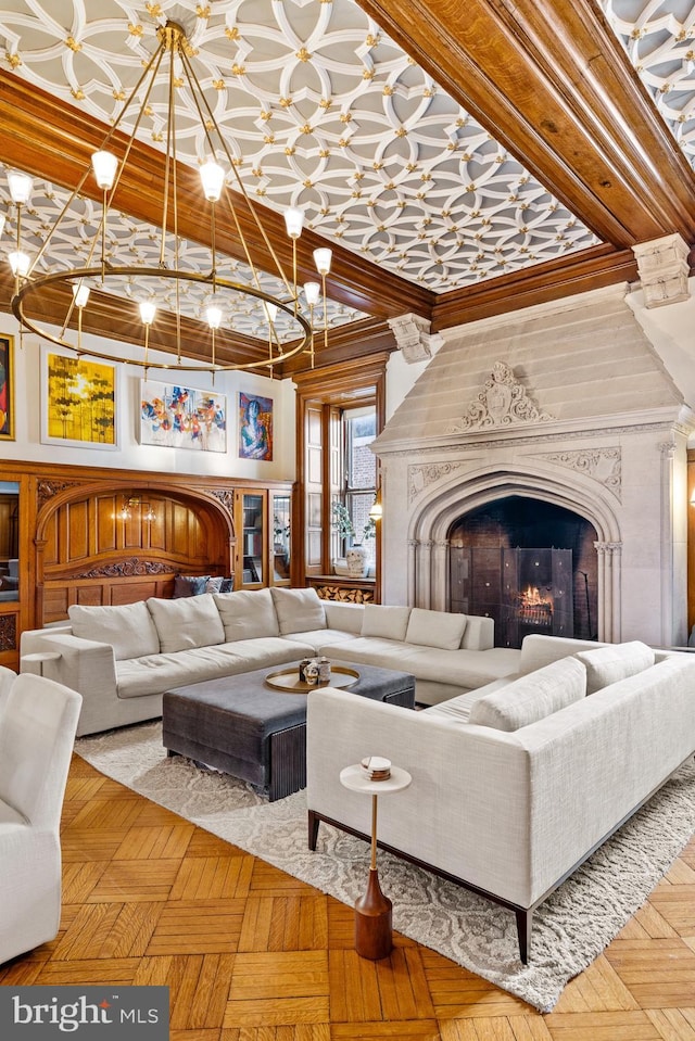 living room featuring parquet floors, a high end fireplace, and ornamental molding