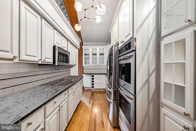 kitchen featuring white cabinets, decorative backsplash, pendant lighting, and appliances with stainless steel finishes