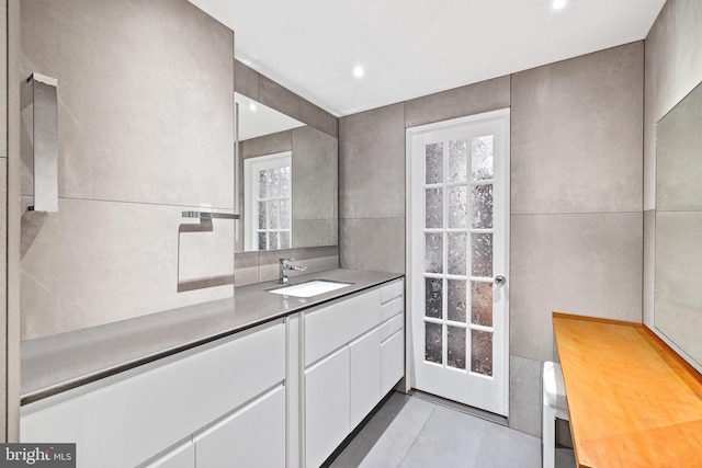 bathroom with vanity, tile patterned floors, and tile walls