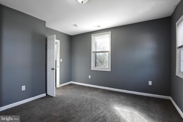 empty room with dark colored carpet