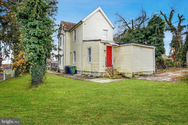 rear view of property featuring a lawn