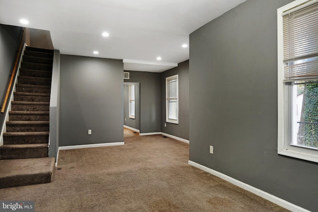 unfurnished living room featuring carpet floors and plenty of natural light