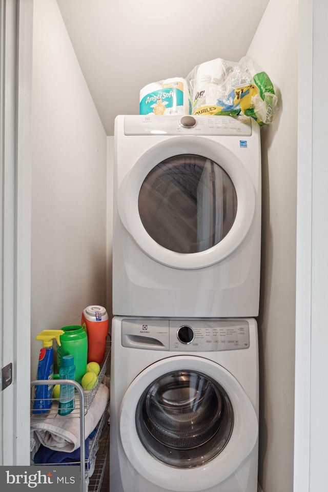 washroom featuring stacked washer / drying machine