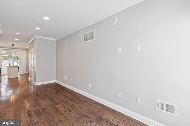 spare room with ornamental molding and dark wood-type flooring