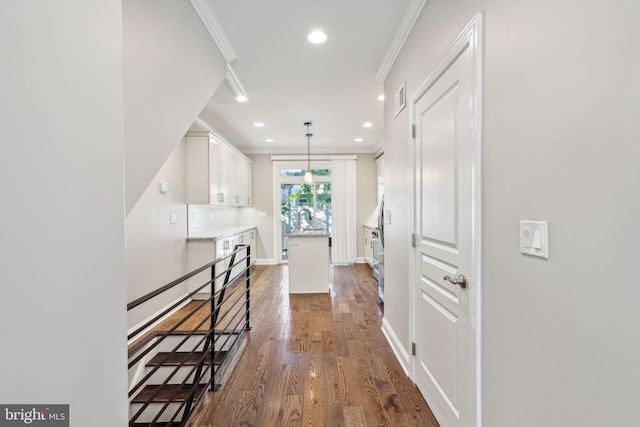 hallway featuring dark hardwood / wood-style flooring, crown molding, and sink