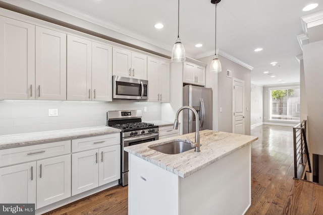 kitchen featuring white cabinetry, sink, hanging light fixtures, stainless steel appliances, and a center island with sink