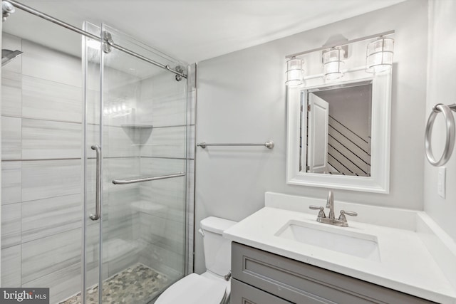 bathroom with vanity, an enclosed shower, and toilet