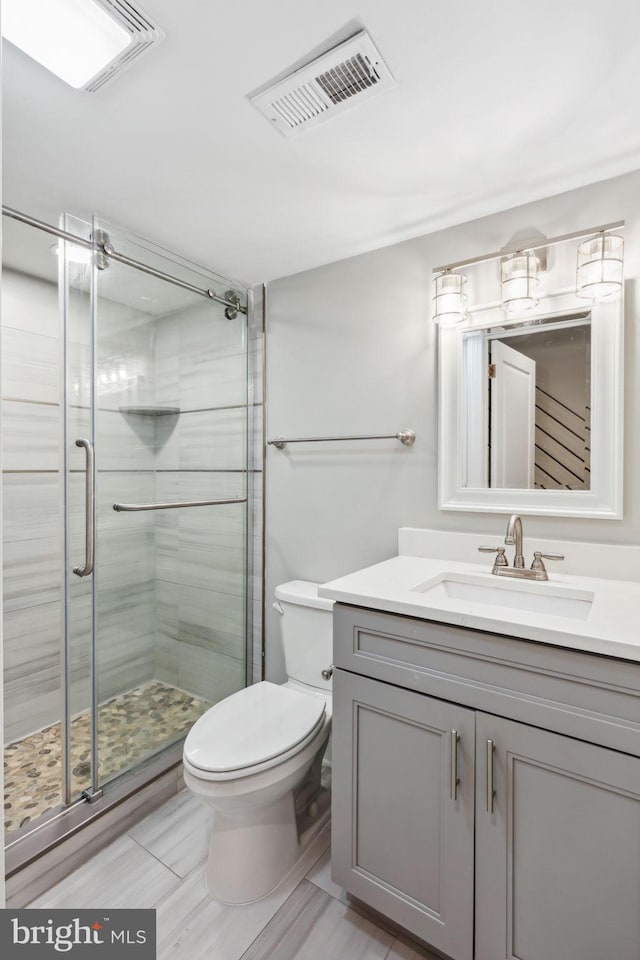 bathroom with vanity, toilet, and walk in shower