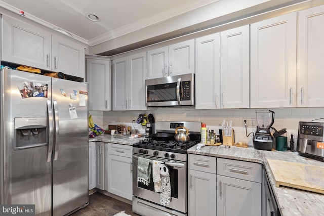 kitchen with light stone countertops, crown molding, and appliances with stainless steel finishes