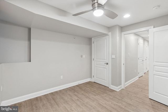 basement with ceiling fan and light wood-type flooring