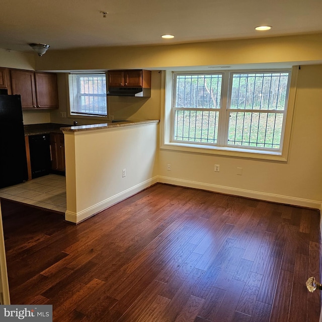 kitchen featuring dark hardwood / wood-style floors, a healthy amount of sunlight, and black appliances