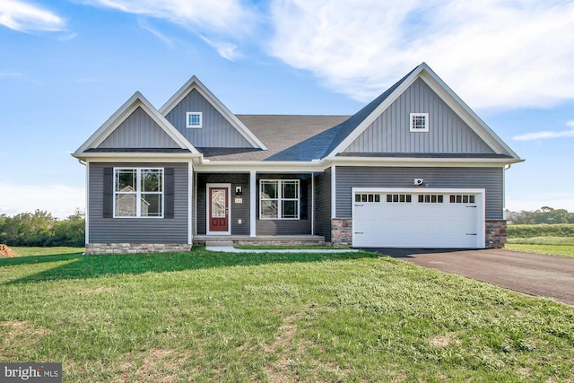 craftsman inspired home featuring a garage and a front lawn