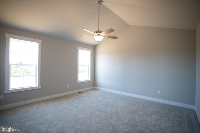 carpeted spare room featuring ceiling fan and lofted ceiling