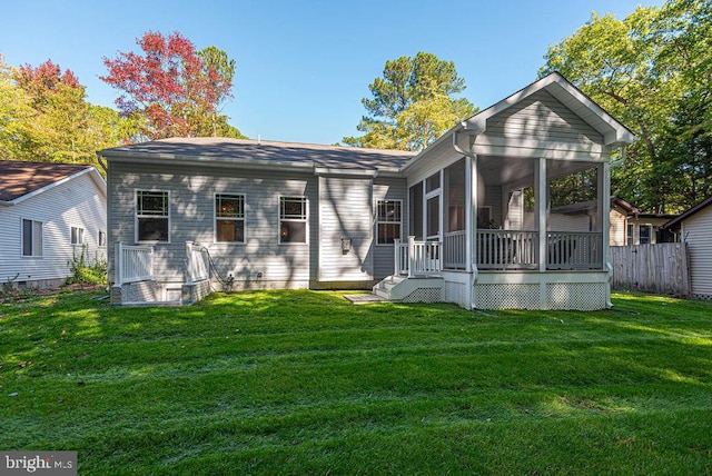 back of property featuring a sunroom and a lawn