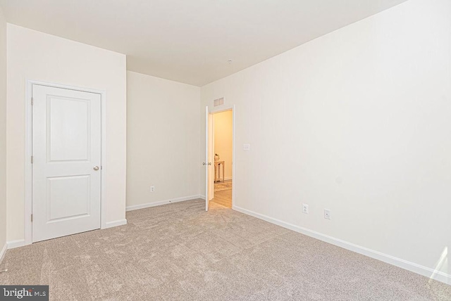 unfurnished room featuring light colored carpet