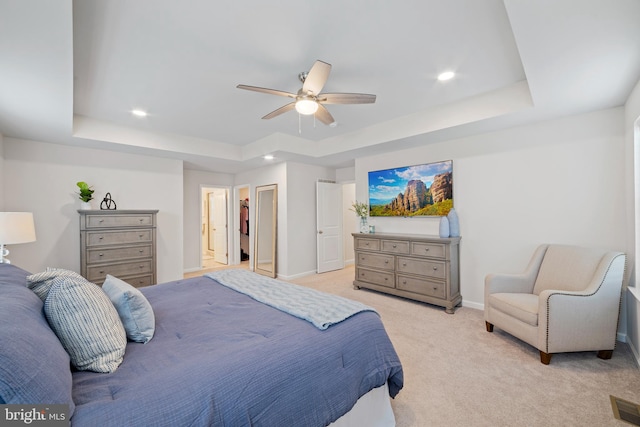 bedroom with ceiling fan, a raised ceiling, and light colored carpet