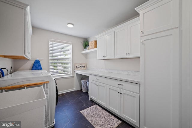 clothes washing area with washer and clothes dryer and cabinets