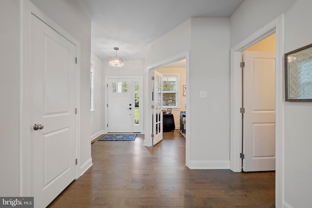 foyer entrance with dark hardwood / wood-style floors and a notable chandelier