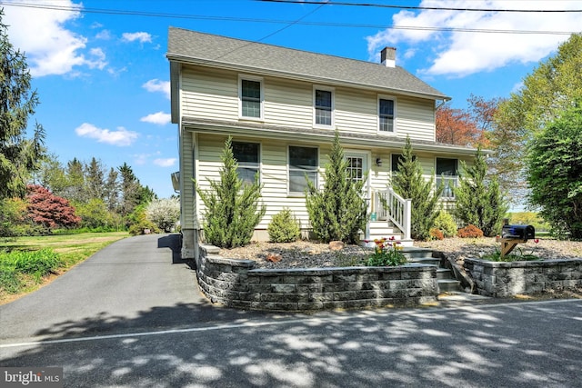 view of front of property featuring a chimney and covered porch