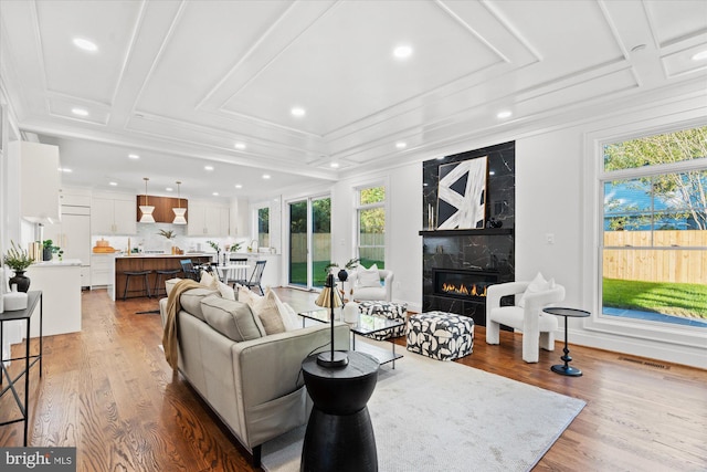 bar featuring tasteful backsplash, ornamental molding, beverage cooler, white cabinets, and light hardwood / wood-style floors